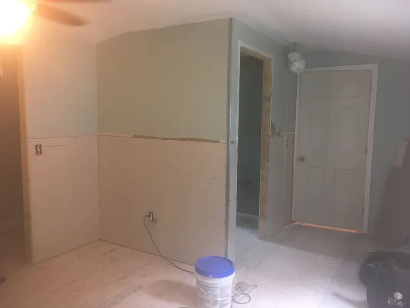 New drywall hung along a wall and doorway