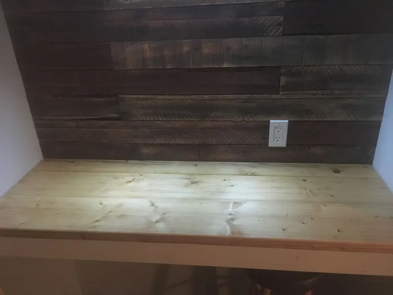 Reclaimed wood accent wall above a built-in pine counter