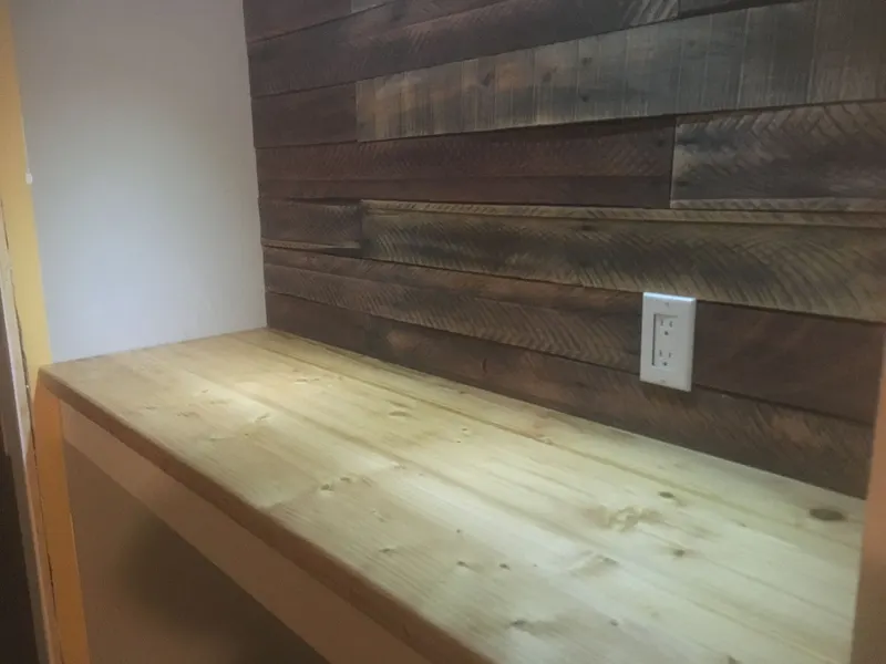 Reclaimed wood accent wall and built-in pine counter in a wall niche