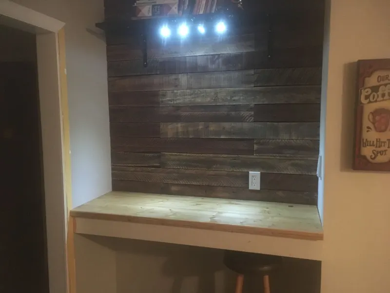 Built-in coffee bar with reclaimed wood wall and lighting