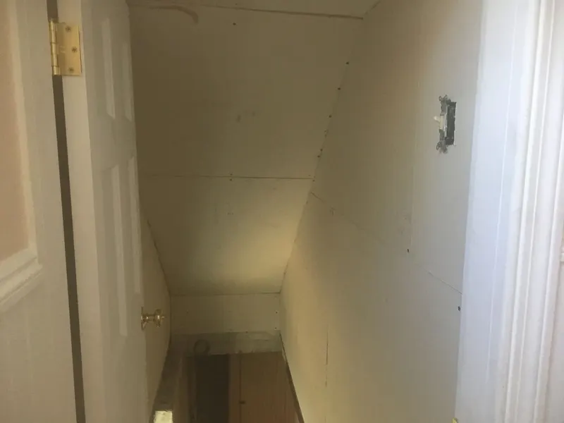 Narrow stairwell with new drywall hung