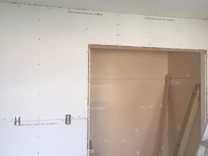 New drywall hung and screwed off around a wide opening