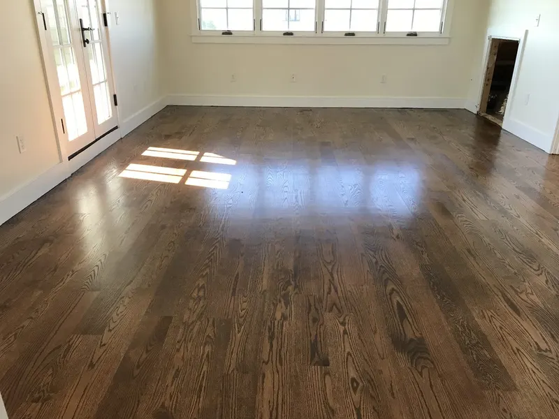 Freshly painted open room with large windows and hardwood floor