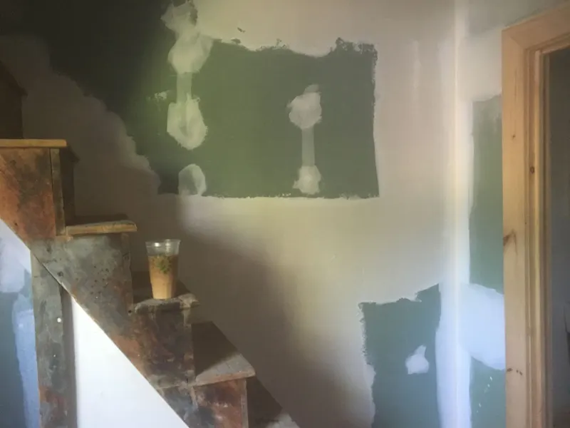 Drywall patches mudded along a stairwell