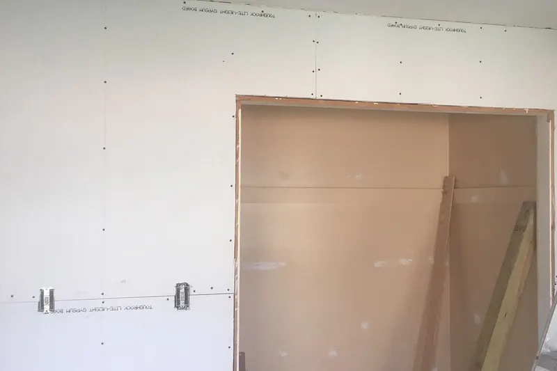 Drywall panel installed around a doorway, taped and ready for finishing